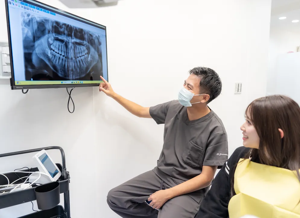 レントゲン画像を見ながら患者さんに説明する院長