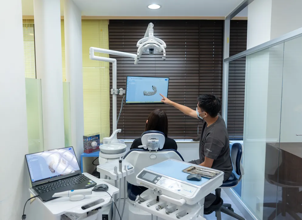 診療室のモニターで口腔内スキャンの画像を説明する院長